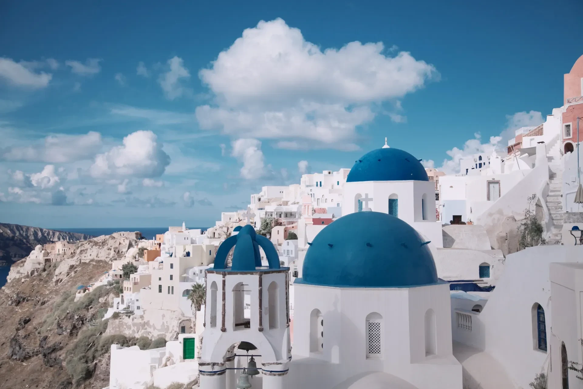 Whitewashed Greek village with blue domes above the Aegean Sea